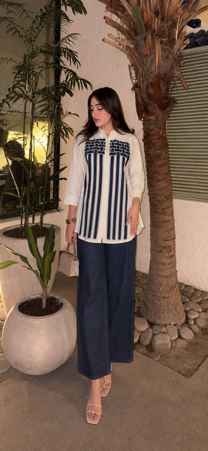 A white shirt with a navy panel, worn with wide denim
